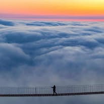 Puente colgante sobre mar de nubes